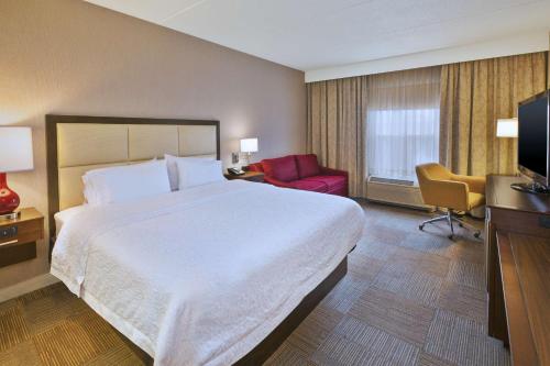 a hotel room with a large bed and a television at Hampton Inn & Suites Providence-Warwick Airport in Warwick