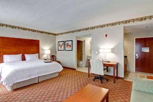 a hotel room with a bed and a desk at Hampton Inn & Suites Leesburg in Leesburg