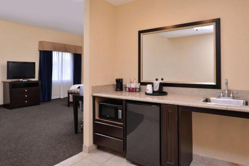 Habitación de hotel con lavabo y espejo en Hampton Inn & Suites Woodward, en Woodward