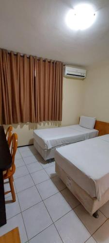 a room with two beds and a window at Hotel Praia 2000 in Fortaleza