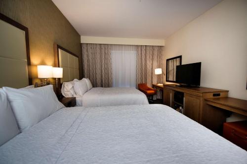 a hotel room with two beds and a flat screen tv at Hampton Inn & Suites Truro, NS in Truro