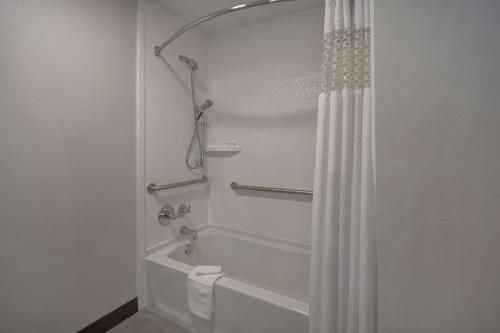 een badkamer met een douche met een wit douchegordijn bij Hampton Inn Potomac Mills Woodbridge in Woodbridge