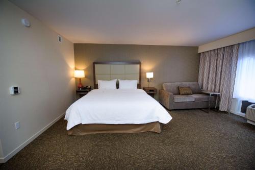 a bedroom with a large white bed and a chair at Hampton Inn & Suites Truro, NS in Truro
