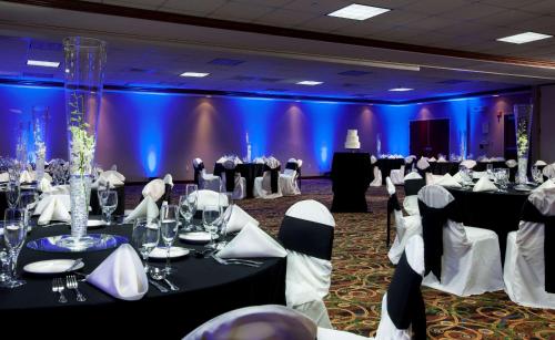a ballroom with tables and chairs in a room with blue lights at Hampton Inn Woodbridge in Woodbridge