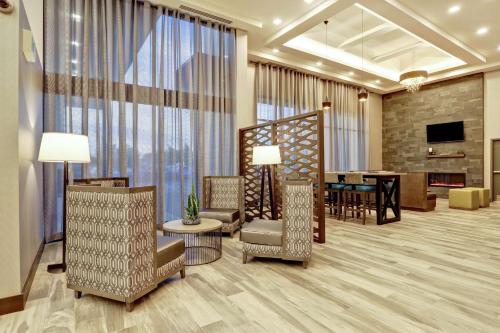 a living room with chairs and a dining room at Hampton Inn St. Catharines Niagara in St. Catharines