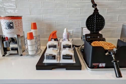 a kitchen counter with a waffle iron and a waffle at Hampton Inn St. Catharines Niagara in St. Catharines