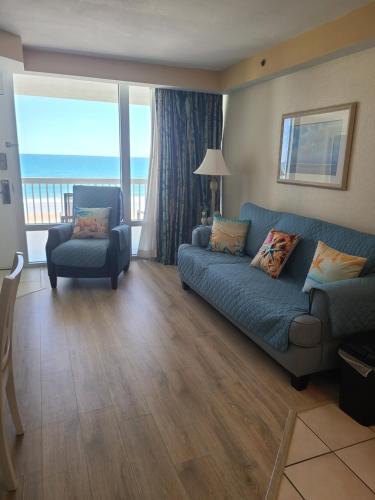 a living room with a couch and a chair at Spectacular Ocean View in Daytona Beach