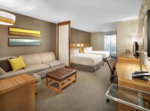 DoubleTree by Hilton Edmonton Downtown في إيدمونتون: غرفة في الفندق مع أريكة وسرير