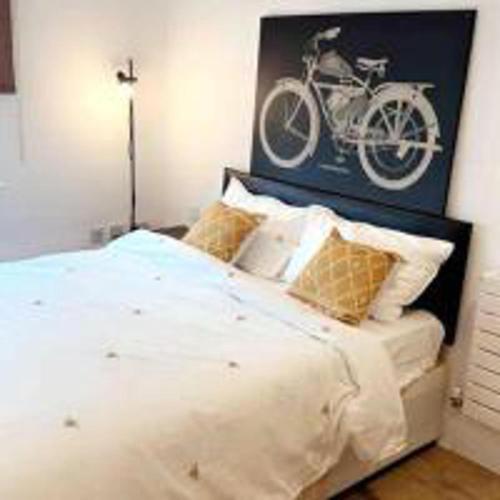 a bedroom with a bed with a bike on the wall at Tee SweetLux Apartment In Canning Town in London
