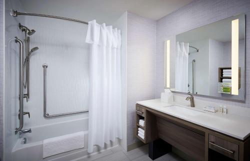 a bathroom with a sink and a shower with a mirror at Home2 Suites By Hilton Brantford in Brantford