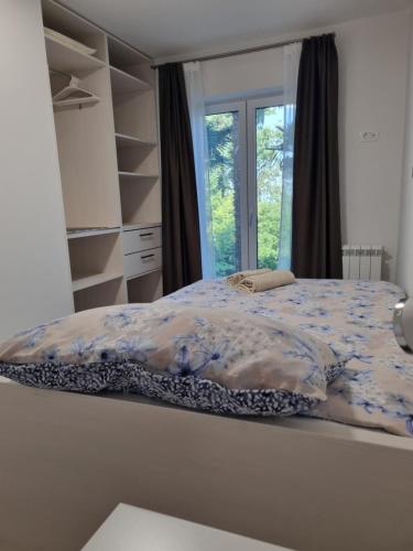 a bedroom with a bed and a window at Apartmani ViVa in Lovran