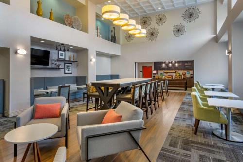 a restaurant with tables and chairs and a dining room at Hampton Inn & Suites Edmonton/West in Edmonton