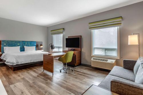 Habitación de hotel con cama, escritorio y sofá en Hampton Inn & Suites Edmonton/West en Edmonton