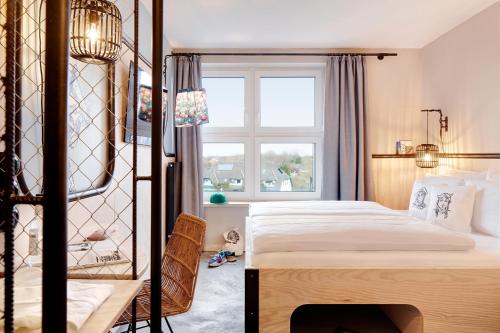 een slaapkamer met een groot bed en een raam bij Bretterbude Büsum in Büsum