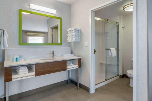 La salle de bains est pourvue d'un lavabo, d'un miroir et d'une douche. dans l'établissement Hampton Inn & Suites Edmonton/West, à Edmonton