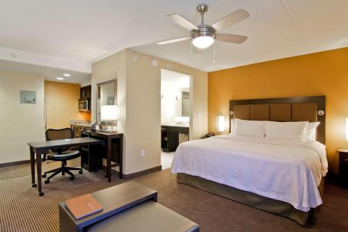 a hotel room with a bed and a desk and a bedroom at Homewood Suites by Hilton Waterloo/St. Jacobs in Waterloo