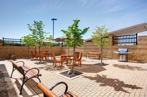 a patio with wooden chairs and tables and trees at Hampton Inn & Suites by Hilton Dartmouth - Halifax in Halifax