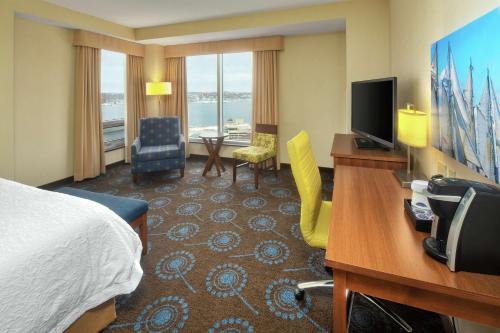 a hotel room with a bed and a desk and a television at Hampton Inn by Hilton Halifax Downtown in Halifax