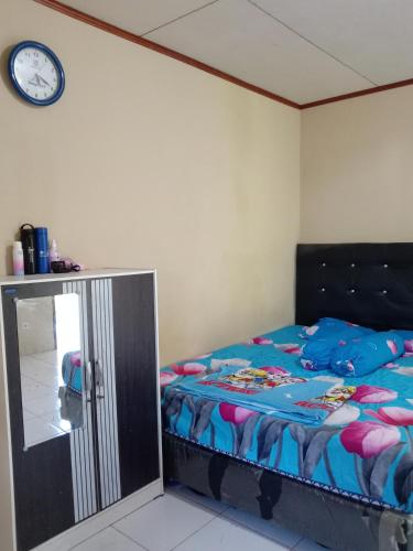 - une chambre avec un lit et une horloge murale dans l'établissement SegeHomestay, à Rinondoran