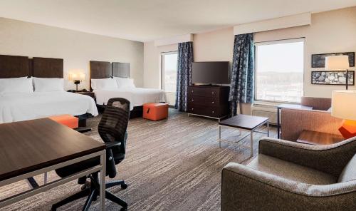 a hotel room with two beds and a desk and chairs at Hampton Inn & Suites by Hilton Dartmouth - Halifax in Halifax