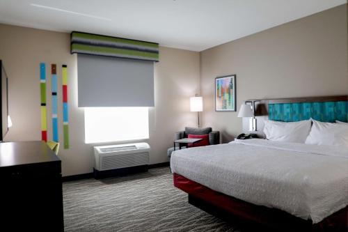 a hotel room with a bed and a window at Hampton Inn Ellensburg in Ellensburg