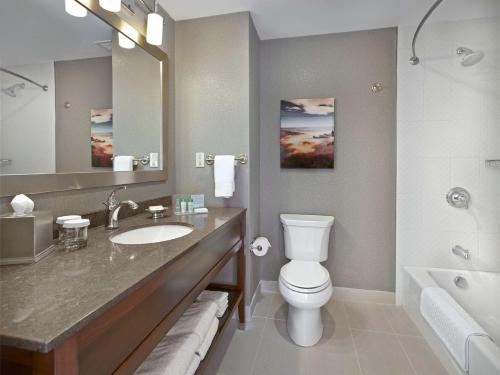 a bathroom with a toilet and a sink and a tub at Hampton Inn by Hilton Halifax Downtown in Halifax