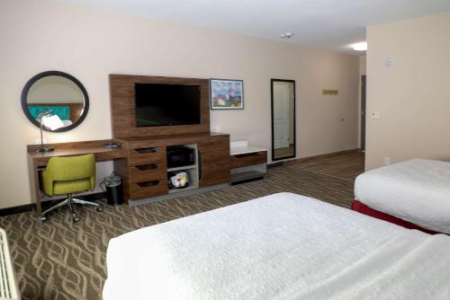 a hotel room with two beds and a flat screen tv at Hampton Inn Ellensburg in Ellensburg