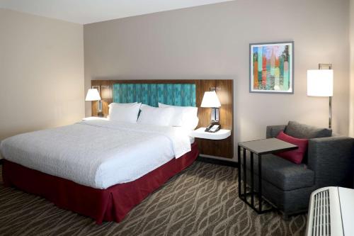 a hotel room with a bed and a chair at Hampton Inn Ellensburg in Ellensburg