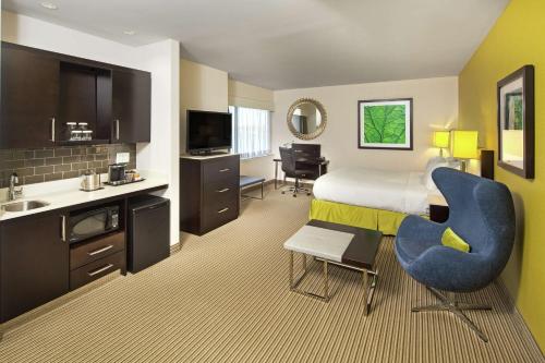 a hotel room with a king sized bed and a kitchen at The Hollis Halifax - a DoubleTree Suites by Hilton in Halifax