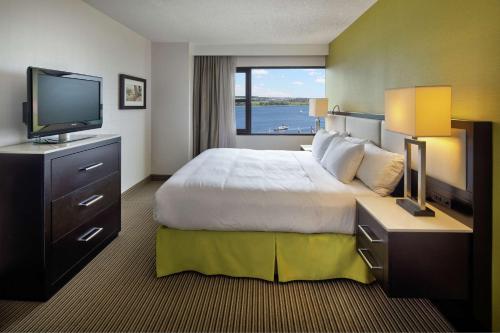 um quarto de hotel com uma cama grande e uma televisão em The Hollis Halifax - a DoubleTree Suites by Hilton em Halifax