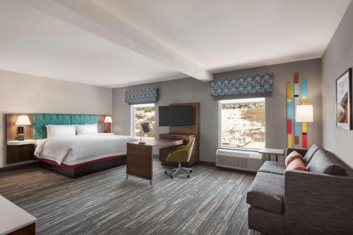 pokój hotelowy z łóżkiem, kanapą i telewizorem w obiekcie Hampton Inn & Suites Kelowna, British Columbia, Canada w mieście Kelowna