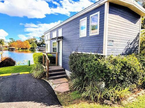 a blue house with a pathway leading to the front door at Orlando Lakefront Tiny Houses in Orlando