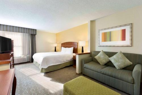 a hotel room with a bed and a couch at Hampton Inn Youngstown/Boardman in Poland