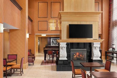a lobby with a fireplace with a television and a piano at Hampton Inn & Suites by Hilton Langley-Surrey in Surrey