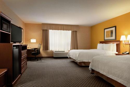a hotel room with two beds and a flat screen tv at Hampton Inn & Suites by Hilton Langley-Surrey in Surrey