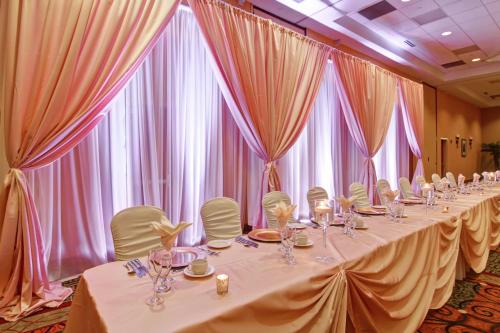 a row of tables in a room with curtains at Hilton Garden Inn Ottawa Airport in Ottawa