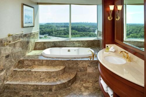 La salle de bains est pourvue d'une baignoire, d'un lavabo et d'une fenêtre. dans l'établissement Hilton Lac-Leamy, à Gatineau