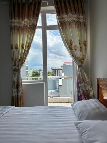 um quarto com uma cama e uma grande janela em HOTEL 86 PHAN THIẾT em Ấp Bình Hưng