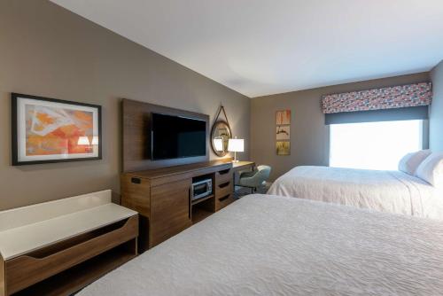 a hotel room with two beds and a flat screen tv at Hampton Inn & Suites Charlottetown in Charlottetown