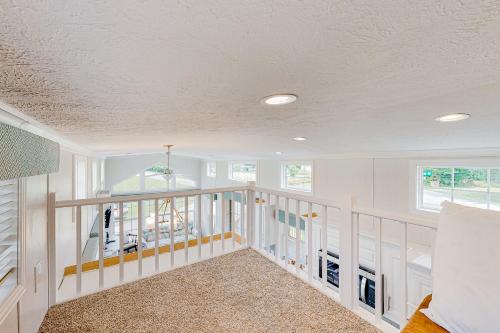 a room with white walls and windows and a staircase at Tiny Charmer in Hendersonville