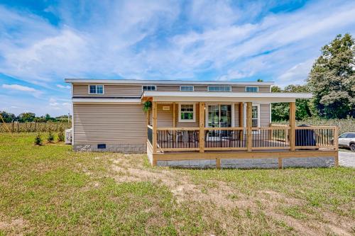 a house with a large deck on a yard at Tiny Charmer in Hendersonville