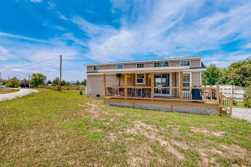 a house with a large deck on a grass field at Tiny Charmer in Hendersonville