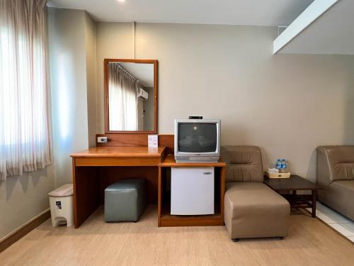 a room with a tv on a desk with a chair at Srivichai Hotel in Nakhon Ratchasima