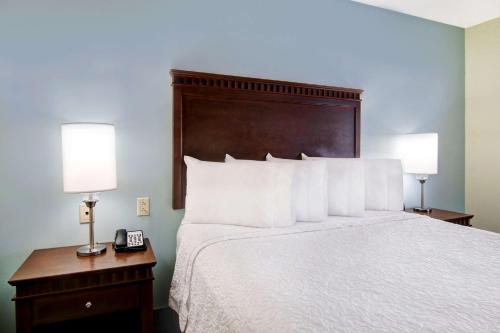 a bedroom with a bed with two lamps and a phone at Hampton Inn & Suites Saint John in Saint John