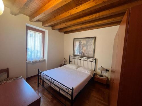 Un dormitorio con una cama y un techo de madera. en Desenzano del Garda Mirella house, en Desenzano del Garda
