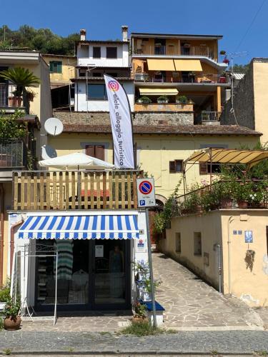 un edificio con un tendone blu e bianco e un cartello di Alele Alloggio turistico a Trevignano Romano