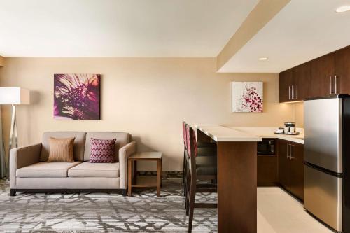 a kitchen and a living room with a couch and a table at DoubleTree by Hilton Hotel Toronto Airport West in Mississauga