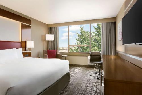 a hotel room with a bed and a large window at DoubleTree by Hilton Hotel Toronto Airport West in Mississauga