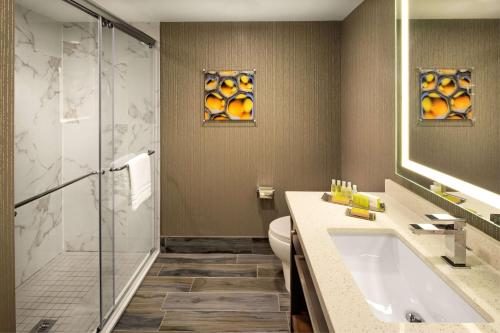 a bathroom with a shower and a sink and a toilet at Doubletree by Hilton Toronto Airport, ON in Toronto