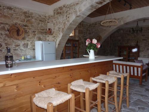 a kitchen with a bar with stools and a counter at The House of Pericles in Silikou